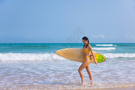 海边比基尼美女冲浪手拿冲浪板背景图片