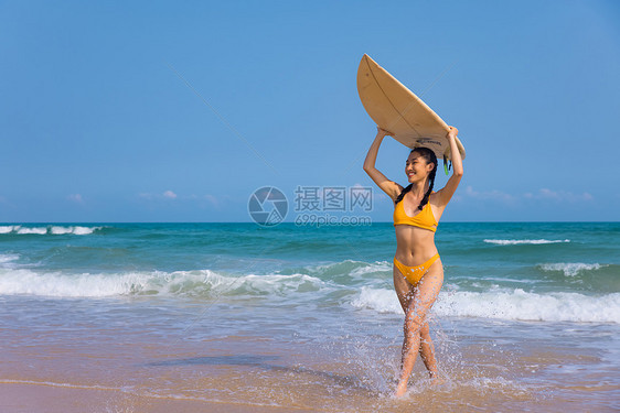 夏日海边比基尼美女头顶冲浪板图片