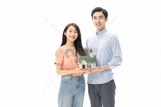 购房买房的青年情侣手捧房屋模型图片