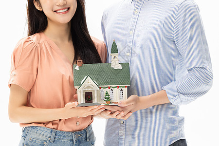 购房买房的青年情侣手捧房屋模型特写图片