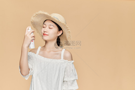 夏日美女戴草帽喷防晒喷雾图片