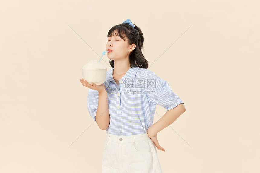 手捧椰子喝椰汁的夏日清凉美女图片