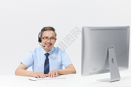 在电脑上前工作的中年男客服图片