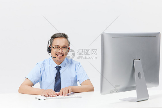 在电脑上前工作的中年男客服图片