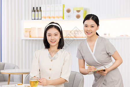 美女顾问美容院服务员接待美女顾客背景
