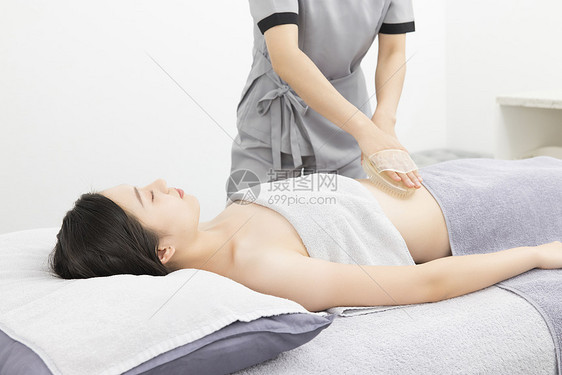 美容院理疗师做腹部spa艾草理疗图片