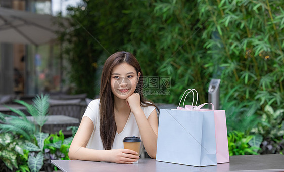 美女购物消费坐在室外咖啡厅图片
