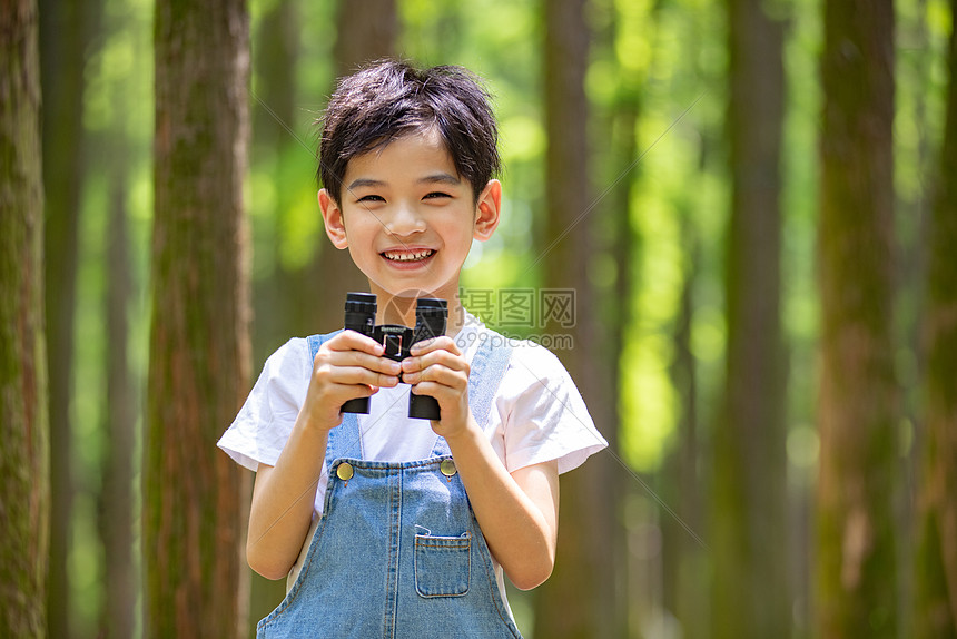 户外树林拿着望远镜的小男孩图片