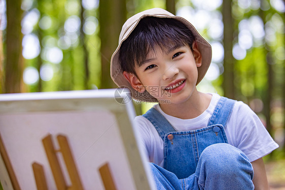 在树林里画画的小男孩图片