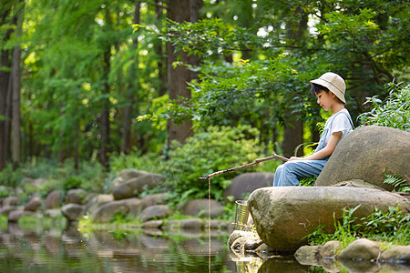 在树林玩耍钓鱼的小男孩图片