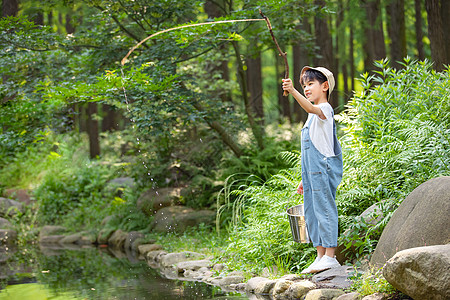 在户外小溪边钓鱼的小男孩高清图片