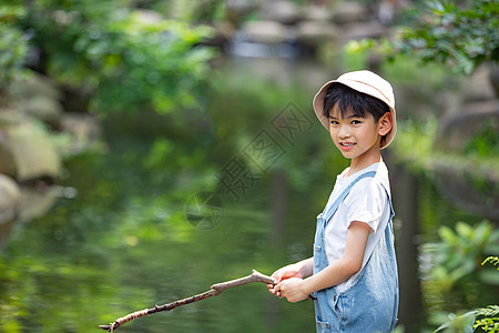 小暑假在户外小溪边钓鱼的小男孩背景