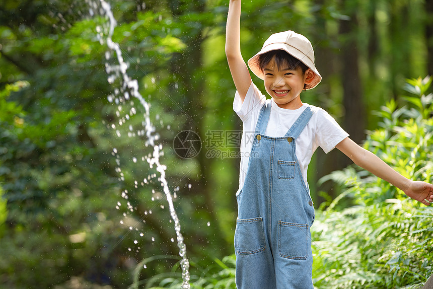 小男孩在溪边欢乐玩水图片