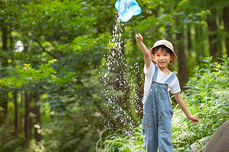 小男孩在森林溪边玩水图片