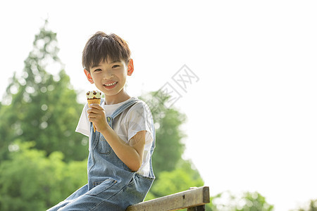 户外吃冰淇淋的小男孩图片