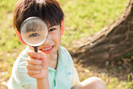 夏天人物拿着放大镜观察的小男孩背景