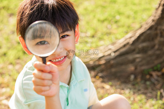 拿着放大镜观察的小男孩图片