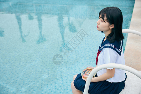日系美女抱着鱼缸坐在泳池边图片