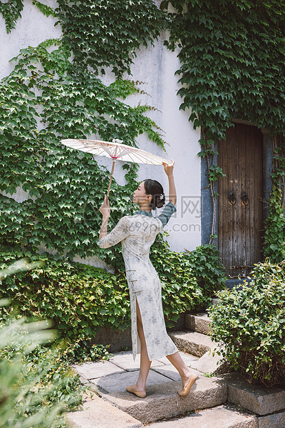 中国风庭院旗袍美女撑油纸伞跳舞图片