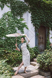 中国风庭院旗袍美女撑油纸伞跳舞背景图片