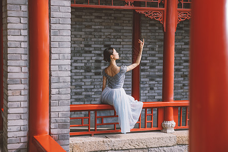 优雅美女坐在中式庭院翩翩起舞图片
