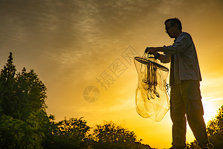 夕阳下捕捞的渔民图片