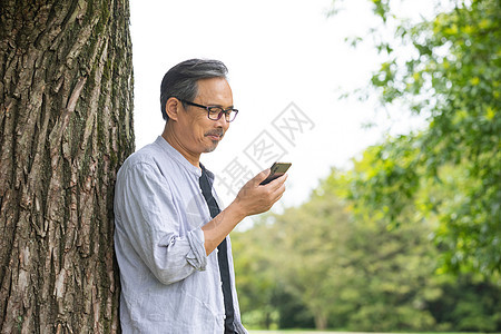 在户外使用手机的成年男性图片