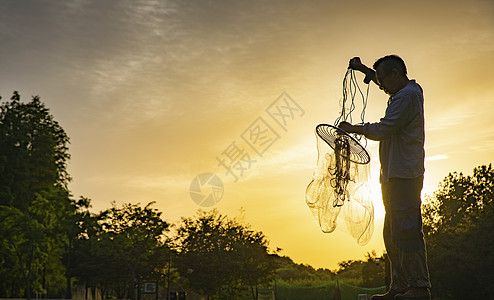 夕阳下渔民收获渔网图片