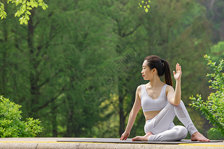 女性在公园里做瑜伽拉伸腿部图片