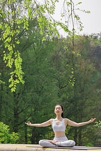 女性公园里做瑜伽张开双手图片