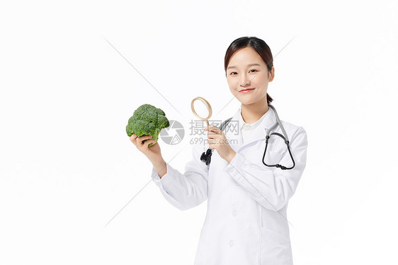 营养学家手拿放大镜观察蔬菜西兰花图片
