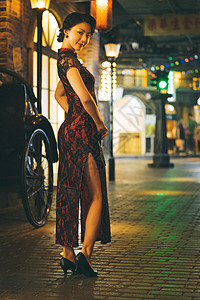城市夜晚霓虹灯下身穿旗袍的窈窕淑女图片