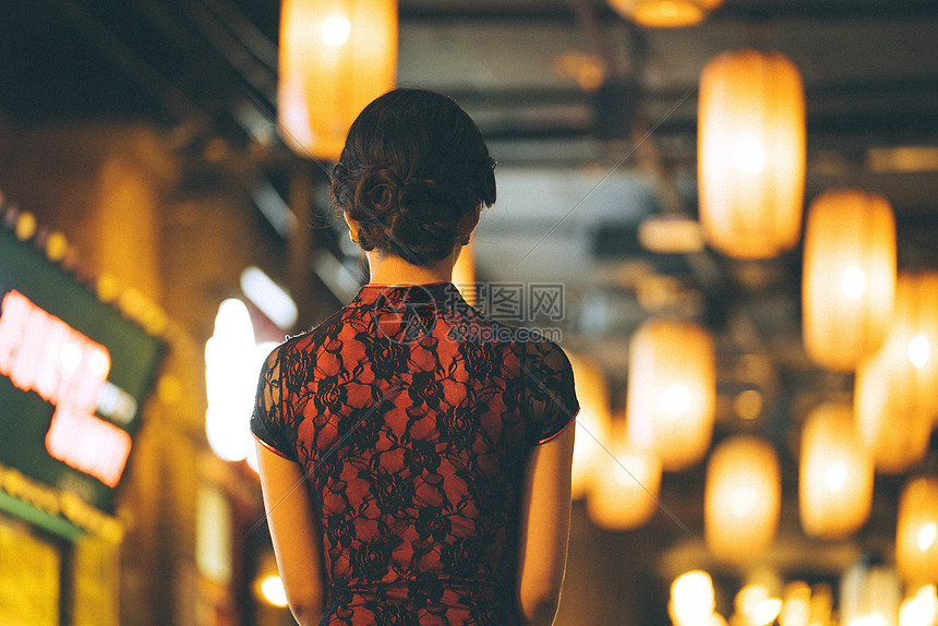 城市夜晚霓虹灯下身穿红色旗袍的美女背影图片