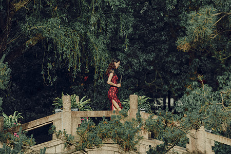 在桥上手拿扇子的旗袍美女图片素材