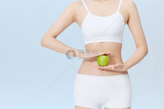 健身青年女性手拿青苹果图片
