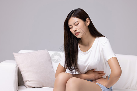 腹部疼痛的居家女性背景图片