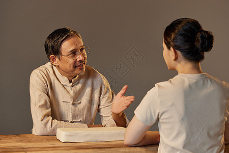 中老年女老中医给女顾客看诊背景