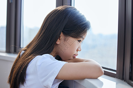 趴在窗前孤独的小女孩图片素材