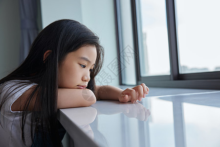 趴在窗前表情难过的小女孩图片素材