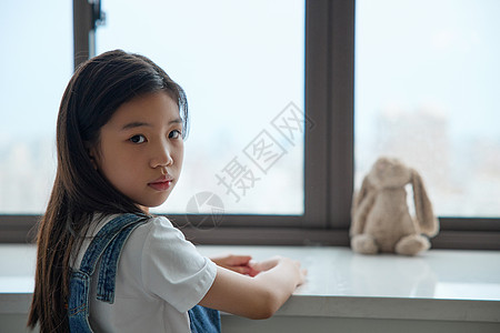 趴在窗前表情难过的小女孩回头图片