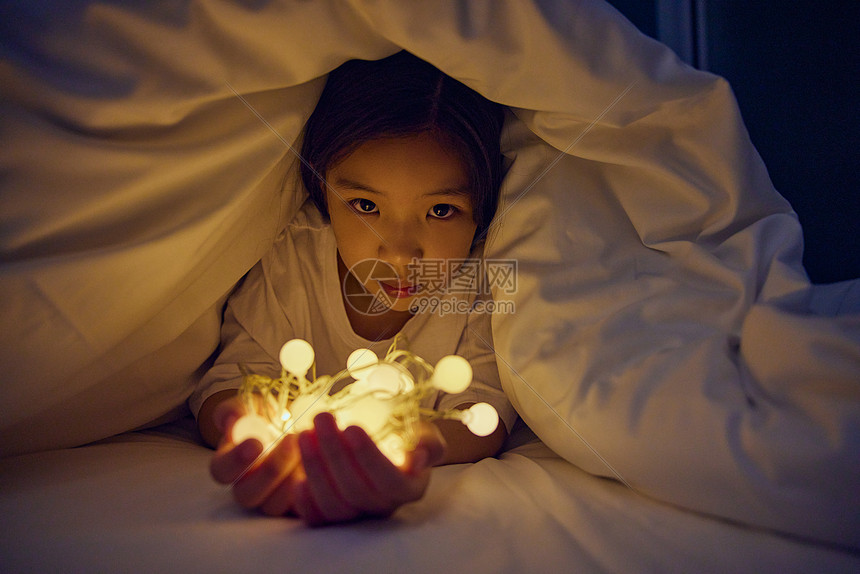 小女孩躲在被子里难过图片