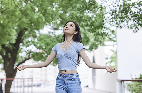 年轻美女张开怀抱享受大自然背景图片