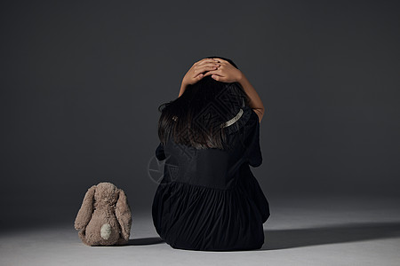孤单小女孩孤独儿童与玩偶的背影背景