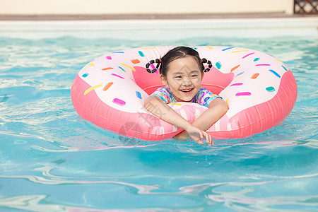 夏日游泳圈小女孩在泳池里面用游泳圈游泳背景