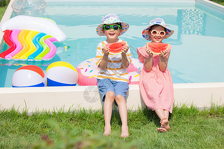 夏天男孩和女孩坐在泳池边开心吃西瓜图片