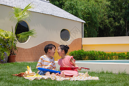 小男孩小女孩坐在野餐垫上玩尤克里里图片