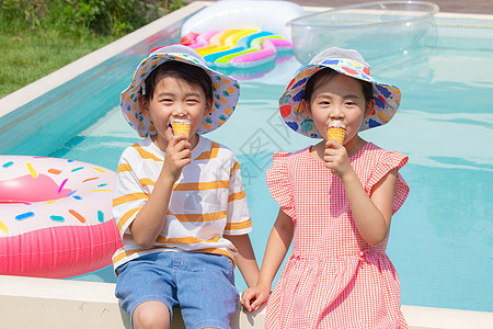 小朋友坐在泳池边开心吃冰淇淋高清图片