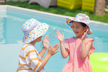 游泳儿童小男孩和小女孩坐在泳池边玩游戏背景