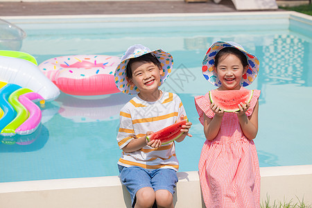 小男孩和小女孩坐在泳池手捧西瓜图片