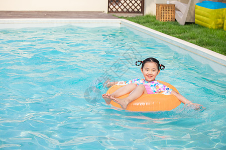小女孩躺在游泳圈上游泳图片